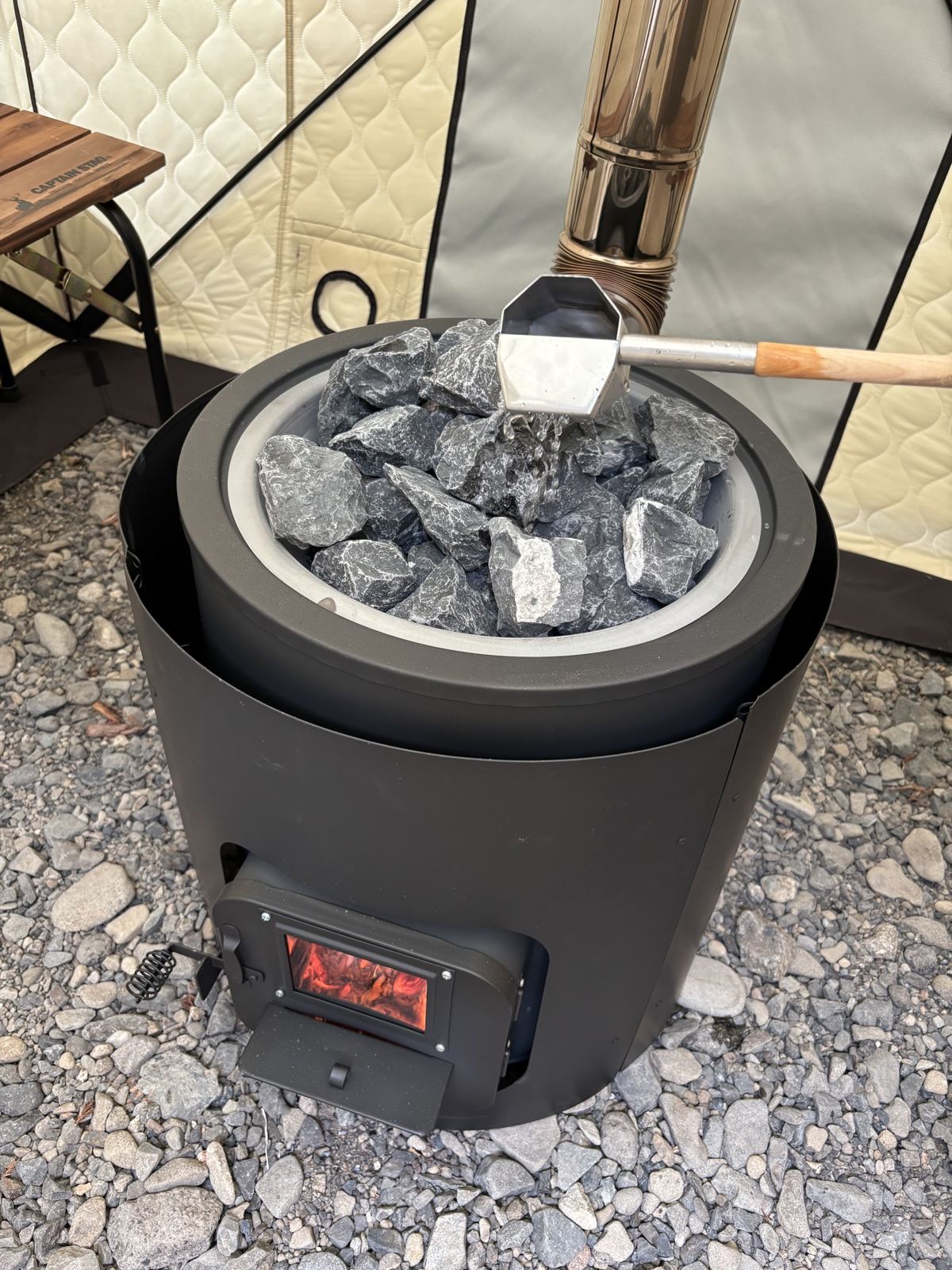 サウナストーンに柄杓で水をかけるロウリュの手元