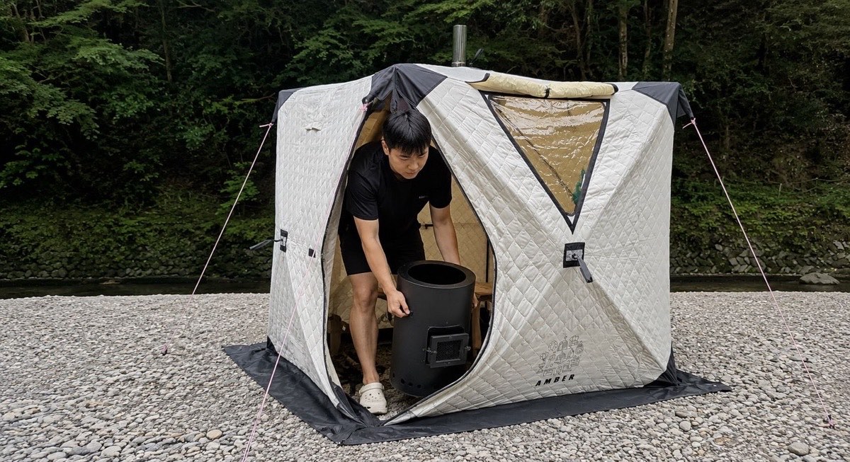 冷えたストーブをテントから運び出している様子